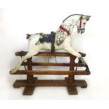 A late Victorian white painted child's rocking horse on a painted wooded plinth,