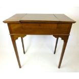 An early 20th century mahogany writing table the lift up top revealing interior with stationery