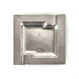 A mid-20th century white metal ashtray with engine turned borders,