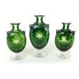 A large green and clear glass twin handled urn style vase with scroll and etched bird to front,