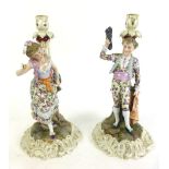 A pair of continental ceramic candle sticks, depicting Matador and fruit picker girl,