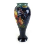 A William Moorcroft vase of slender tapering form decorated in the 'Pomegranate' pattern with