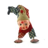 A celluloid headed 20th century wind up toy in the form of child clown waling on his hands