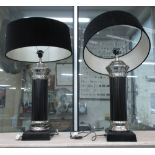 TABLE LAMPS, a pair, of substantial proportions, plush black shades on black column bases, 83cm H.