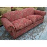 SOFA, two seater, with geometric design fabric on a red ground on bun supports, 218cm L.