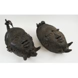 TIKA BRONZE FACE MASKS, a companion pair, each 44cm H.