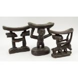 TRIBAL HEAD RESTS, three various, West African carved wooden examples all with figurative supports,