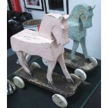 WOODEN TOY HORSES, on wheels, a matched pair, 1950's style, in distressed painted finish,