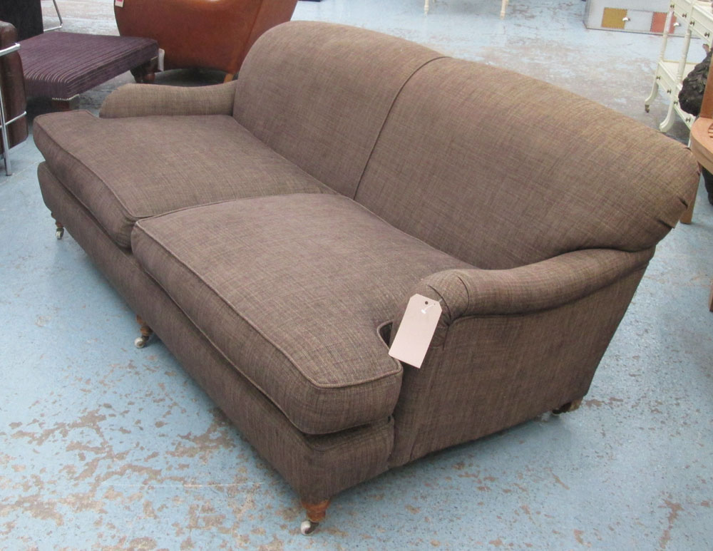 SOFA, Howard style, with brown upholstery on short turned front supports with castors, 195cm L.