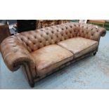 CHESTERFIELD, in antique effect buttoned, tanned leather, on turned supports, 234cm L.