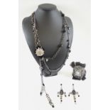 ERICKSON BEAMON SWAROVSKI MULTICHAIN NECKLACE with a lace embellished cuff and matching earrings.