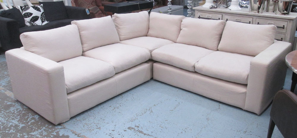 CORNER SOFA, in three sections with beige upholstery, 257cm x 259cm.