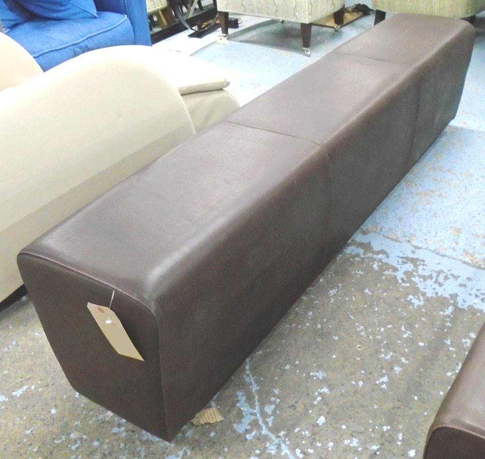 OTTOMAN, in a burnt umber leather, on a long wooden support, 179cm L.