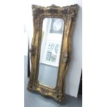 WALL MIRROR, gilt effect frame, with flowerhead and scroll decoration, and a bevelled plate,