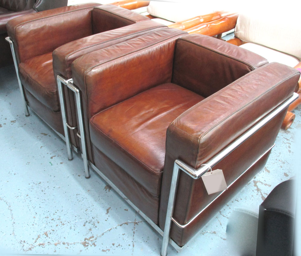 ARMCHAIRS, a pair, Le Corbusier design tubular chrome framed with tan leather cushions, 77cm W.