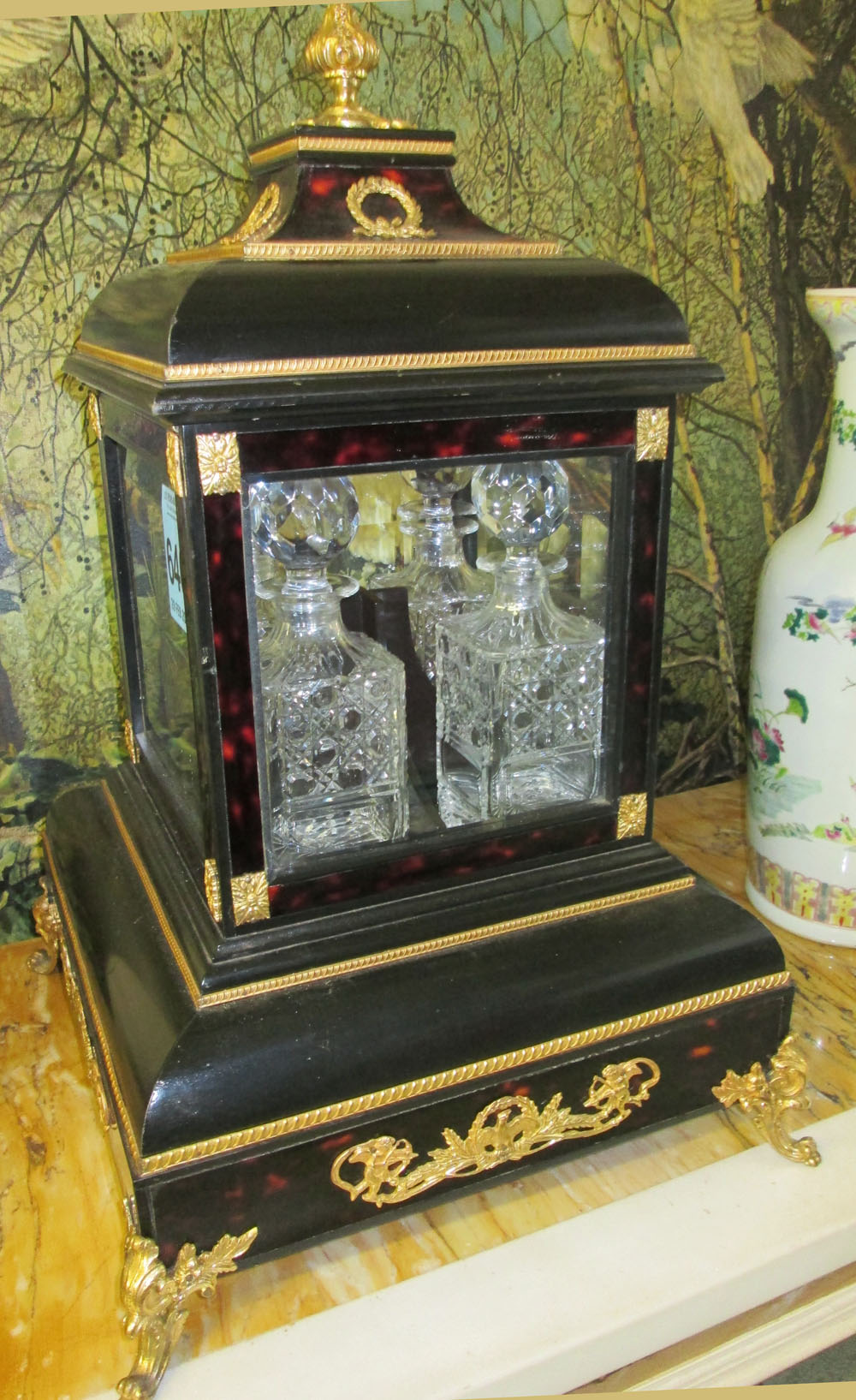 TANTALUS, French style, ebonised and faux tortoiseshell with gilt metal mounts and glazed sides,