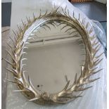 MIRROR, bevelled in a silver painted frame with faux antler decoration, 114cm x 81cm.