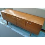 SIDEBOARD, 1960's teak with three short drawers and three panelled cupboard doors enclosing shelves,