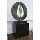 CIRCULAR SCULPTURE, patinated metal with central figure, marble block base, 70cm H overall.