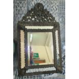 WALL MIRROR, 19th century Flemish patinated brass with bevelled plate in a cushion frame,