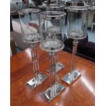 TABLE CANDLE LIGHTS, a set of four, B&B Italia style plated metal bases with circular glass tops,