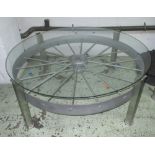 LOW TABLE, 'bespoke' with circular glass top, metal wheel base, 122cm diam x 48cm H.