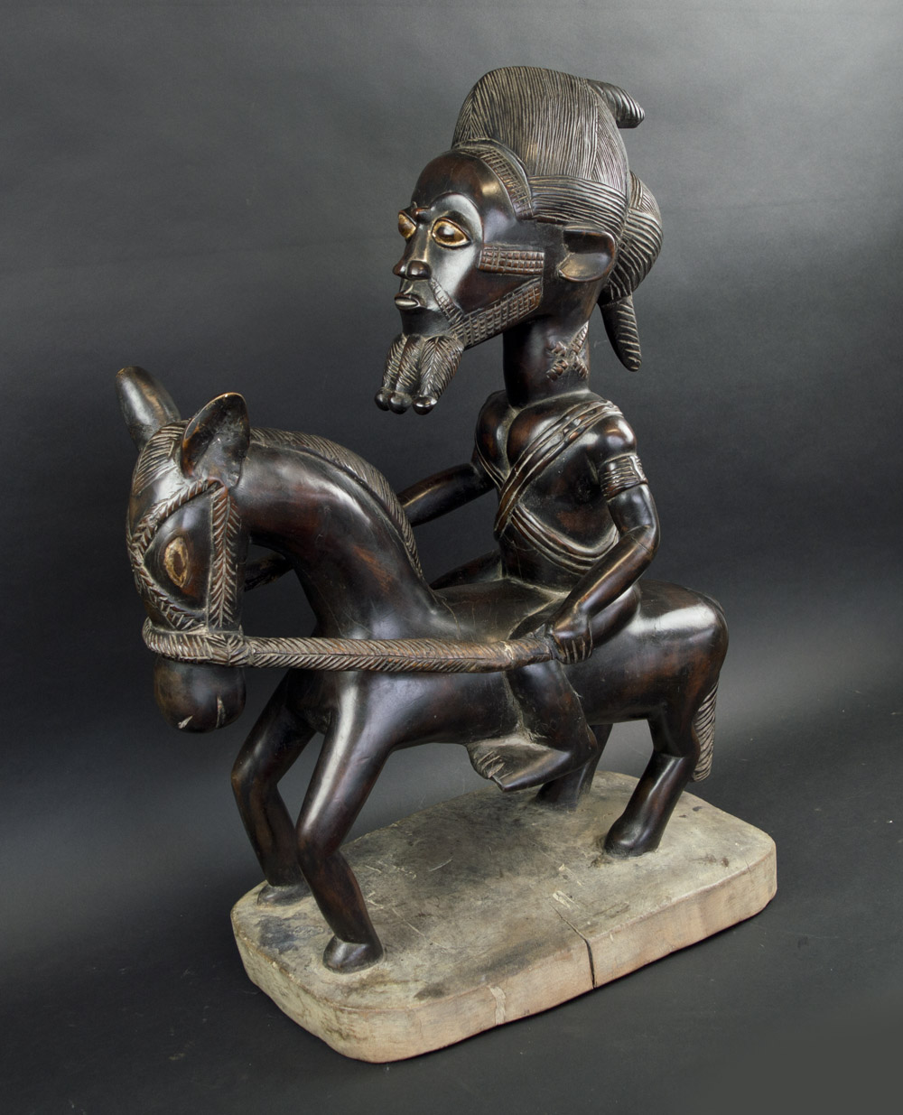 BAULE HORSEMAN CARVING, patinated finish, with integral base, 53cm L x 69cm H overall.