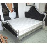 BED of substantial proportions, the silver rococco gilt frame with tall buttoned headboard,