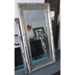 WALL MIRROR, rectangular with an elaborate silver gilt frame and bevelled plate, 91cm W x 183cm H.