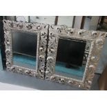 MIRRORS, a pair, with bevelled plate and silver coloured border, with foliate decoration,