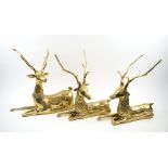 BRASS STAGS, a group of three in seated poses, largest 50cm L x 44cm H max.