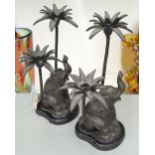 CANDLESTICKS, a pair, in the form of Indian elephants with two palm trees, each 32cm x 28cm.