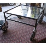 LOW TABLE, of the industrial persuasion, on four wheels and with a tempered glass top,