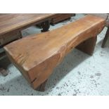 RUSTIC TREE BENCH, rustic plain tree section on twin supports, 64cm H x 155cm.