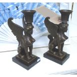 CANDLESTICKS, a pair, in bronze in the form of a sphinx, 32cm H.