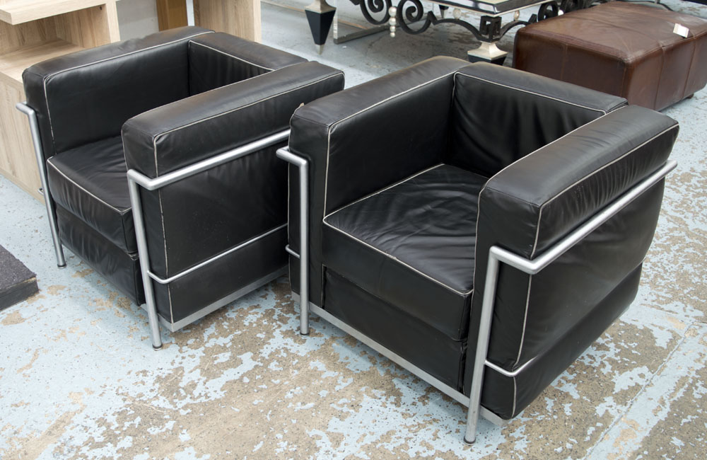 ARMCHAIRS, a pair, Le Corbusier style, black leather on metal supports, 76cm W.