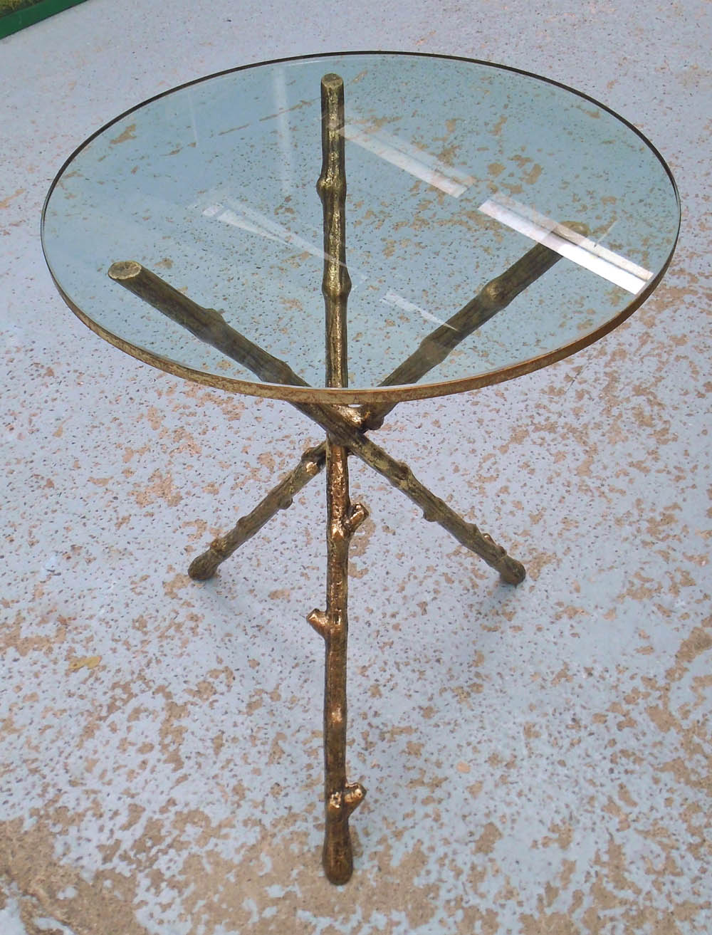 OCCASIONAL TABLE, the circular glass top on a triform base on gilt metal, in the form of branches,