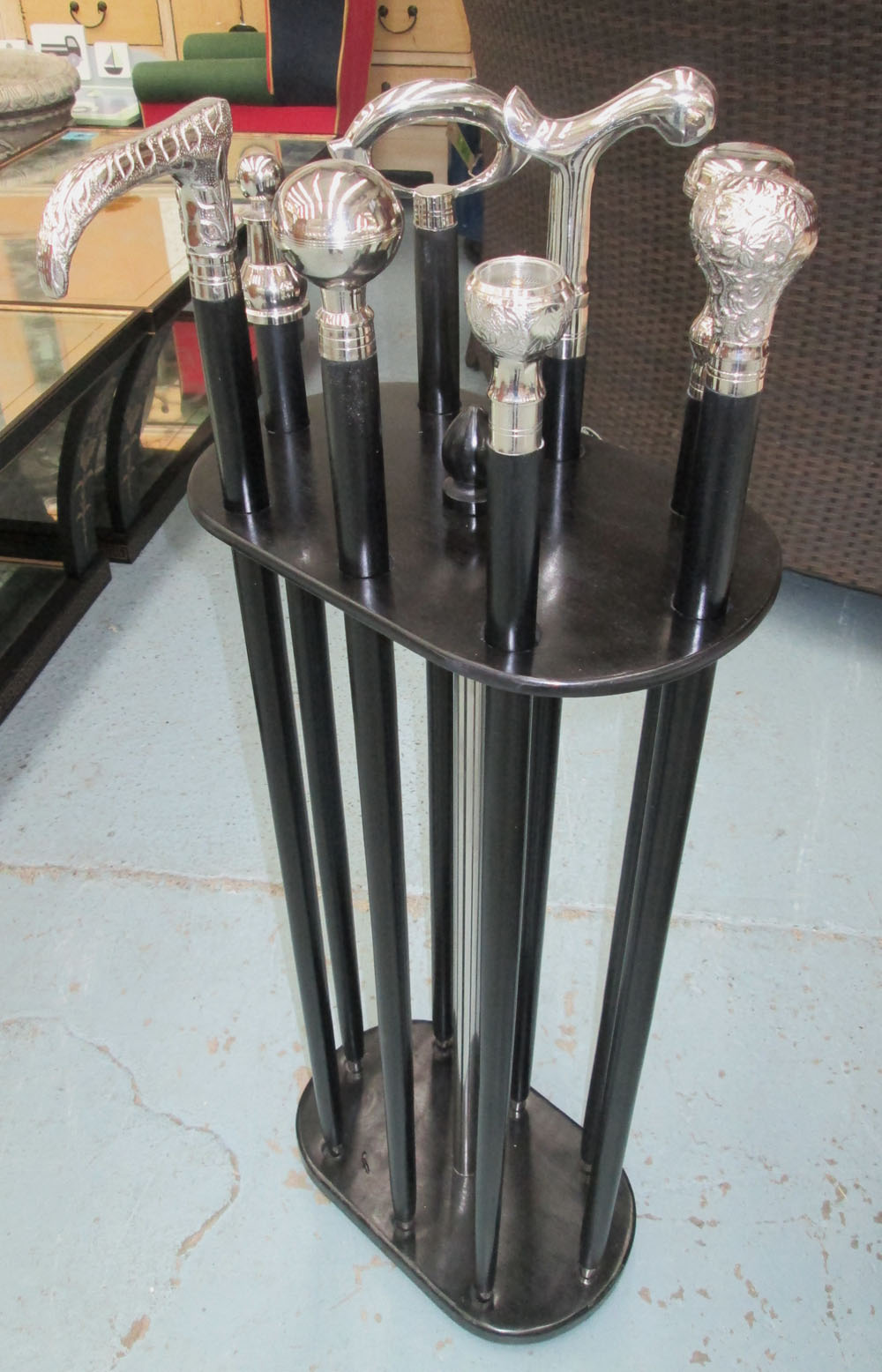 STICK STAND, ebonised, with eight walking sticks, 97cm H.