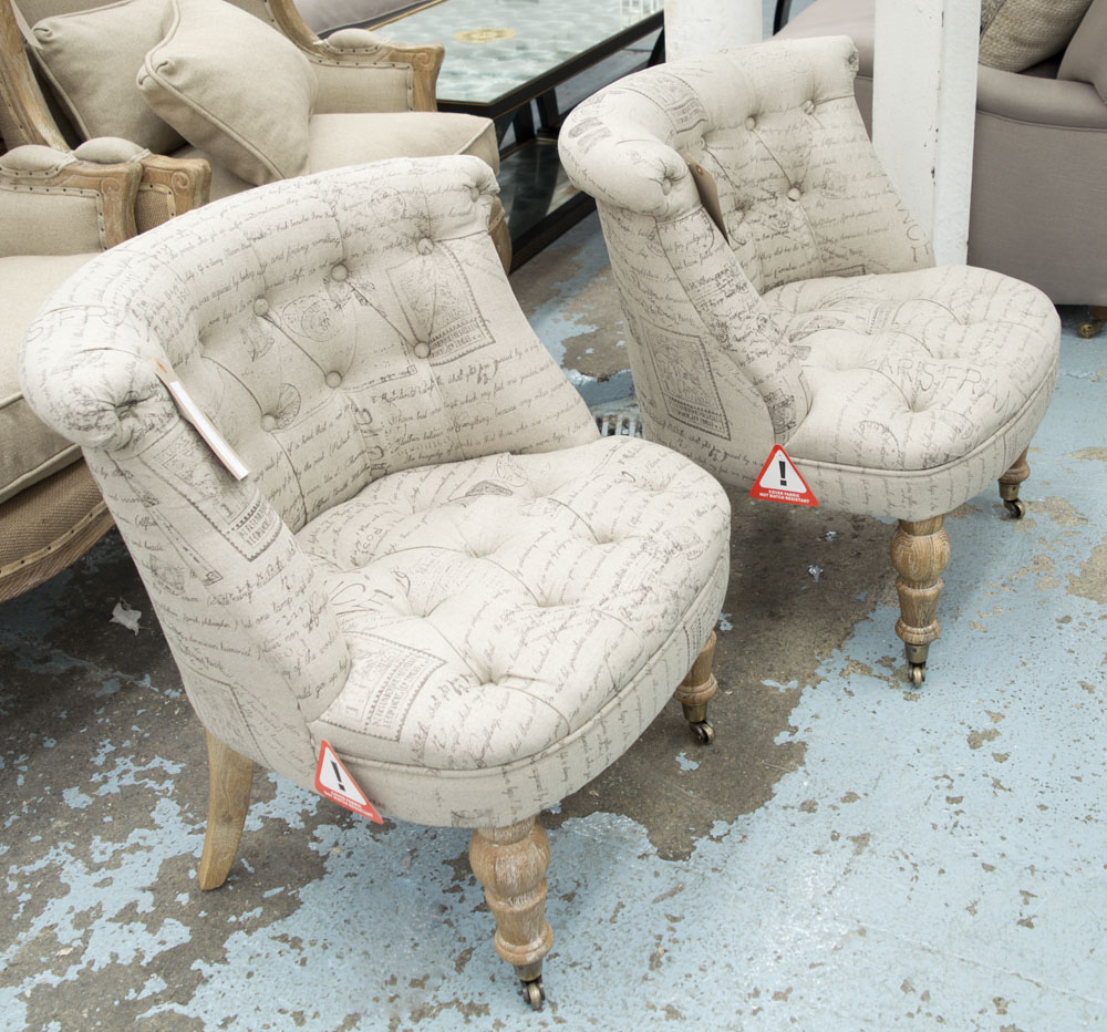 BEDROOM CHAIRS, a pair, button back, in printed fabric on front castors, 66cm W.