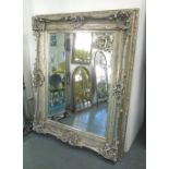WALL MIRROR, elaborate silver gilt frame and bevelled plate, 114cm x 139cm.