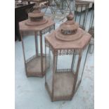 STORM LANTERNS, a pair, of large proportions, in glass with distressed metal case, 93cm x 38cm.