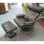 ARMCHAIR, tanned leather recliner on swivel base, with matching footstool, 94cm W.