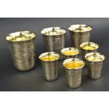 RUSSIAN TUMBLERS, eight various sizes, hallmarked silver gilt, with engraved decoration,