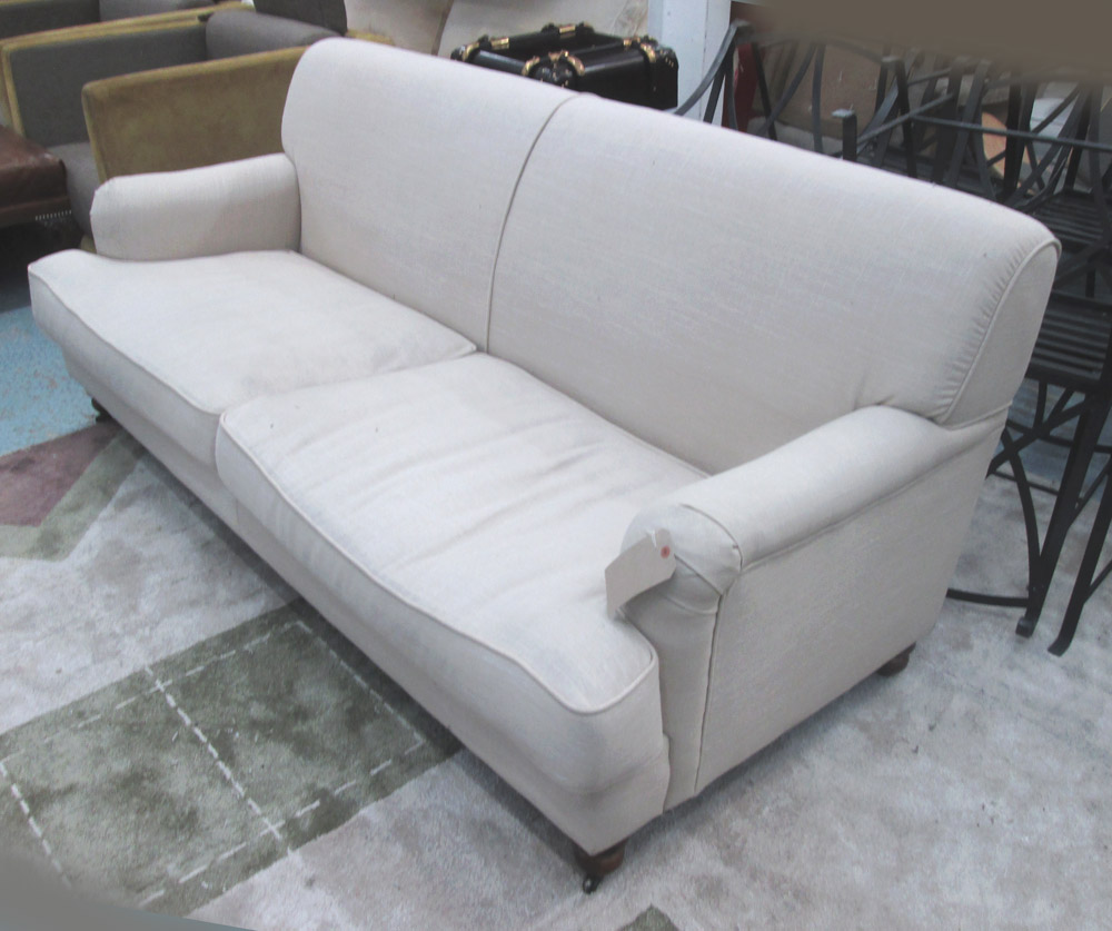 SOFA, two seater, in oatmeal fabric on turned castor supports, 198cm L.
