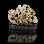 RETICULATED CELADON JADE 'WUFU' BOULDERQING DYNASTY, 18TH CENTURYcarved in high relief to show