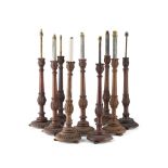 GROUP NINE CARVED WOOD TABLE LAMPS EARLY 20TH CENTURY with slender leaf carved stems and circular