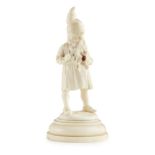 SMALL GERMAN CARVED IVORY FIGURE OF A GNOME 19TH CENTURY wearing a pointed hat with a stained red