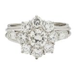 A diamond set cluster ringclaw set with a round brilliant cut diamond, in a single border of smaller