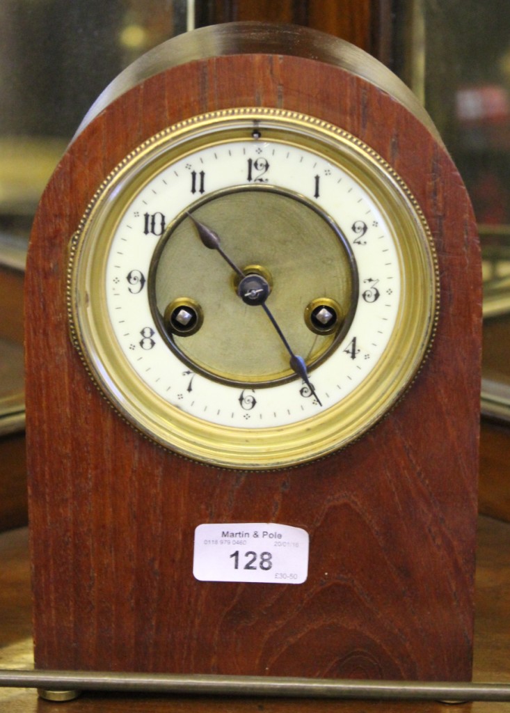 A late 19th century clock movement and brass dial with enamel chapter ring in later arched case,