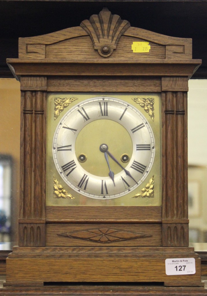 An oak cased mantel clock, the brass dial with silvered chapter ring, the German movement with count